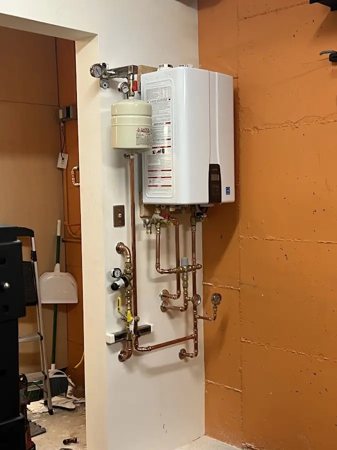 Plumbing technician inspecting water heater connections in Country Club Estates